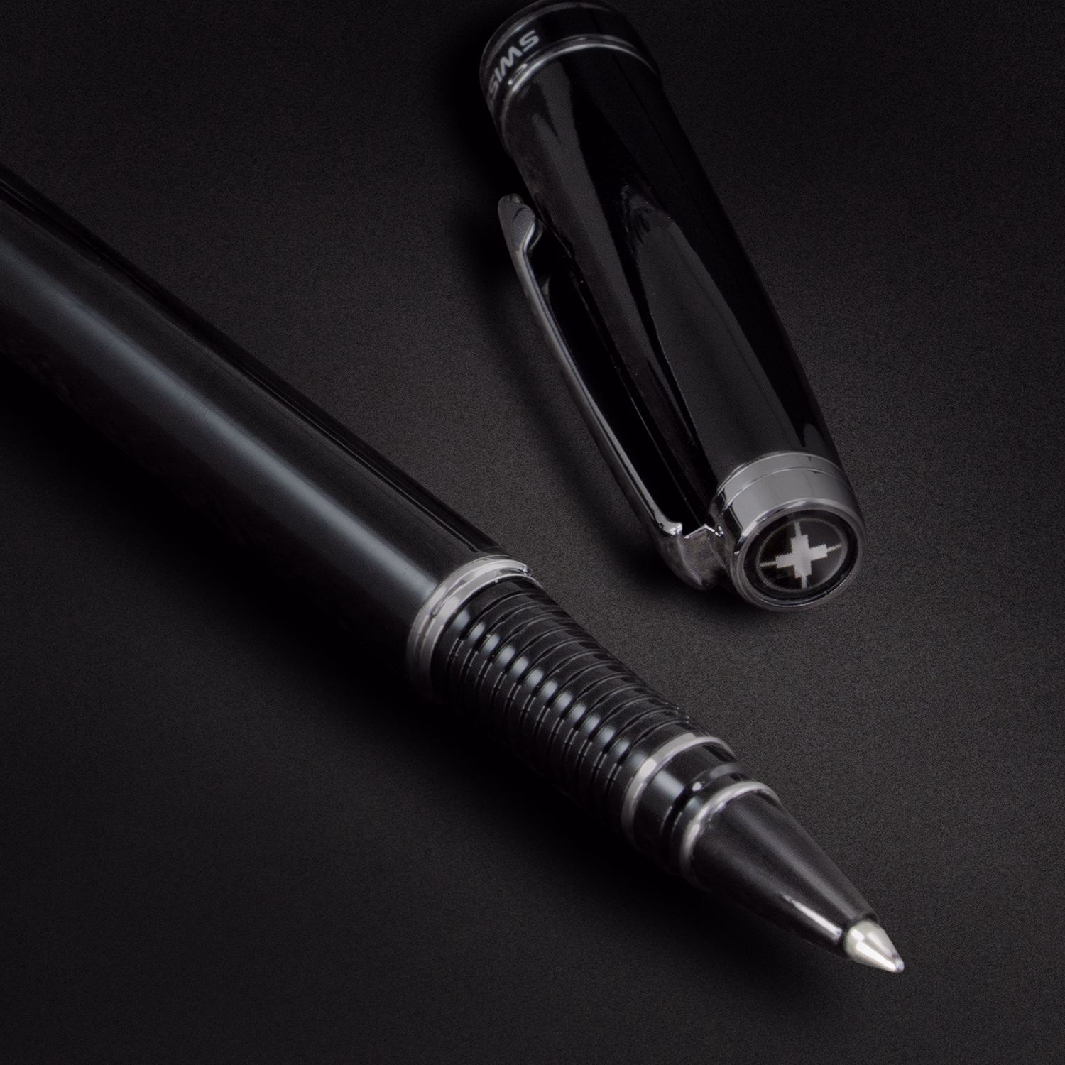 Close-up of black deluxe rollerball pen Swiss Peak brand with silver accents on dark background