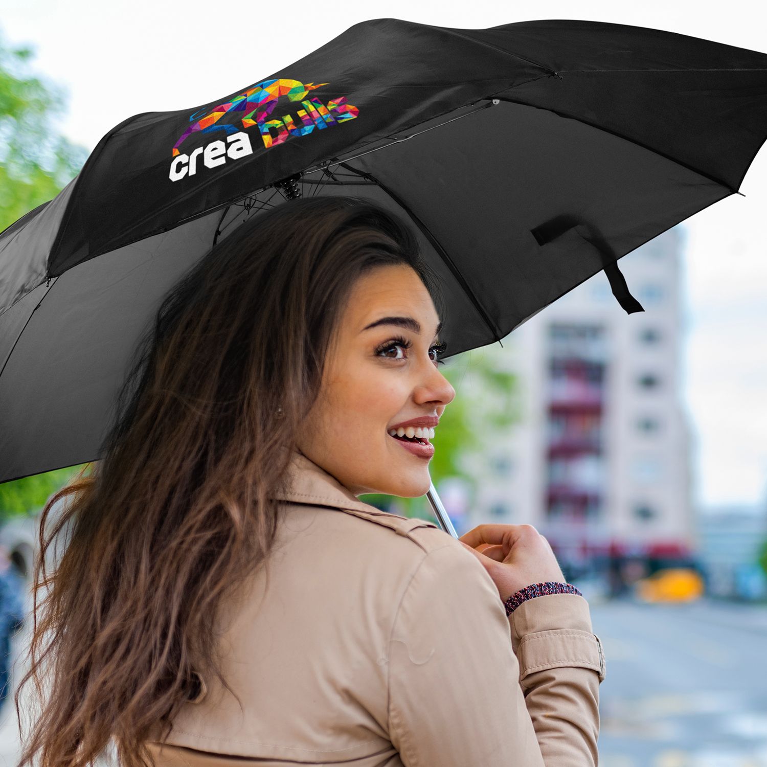 Person holding Avon Compact umbrella in black with branded canopy