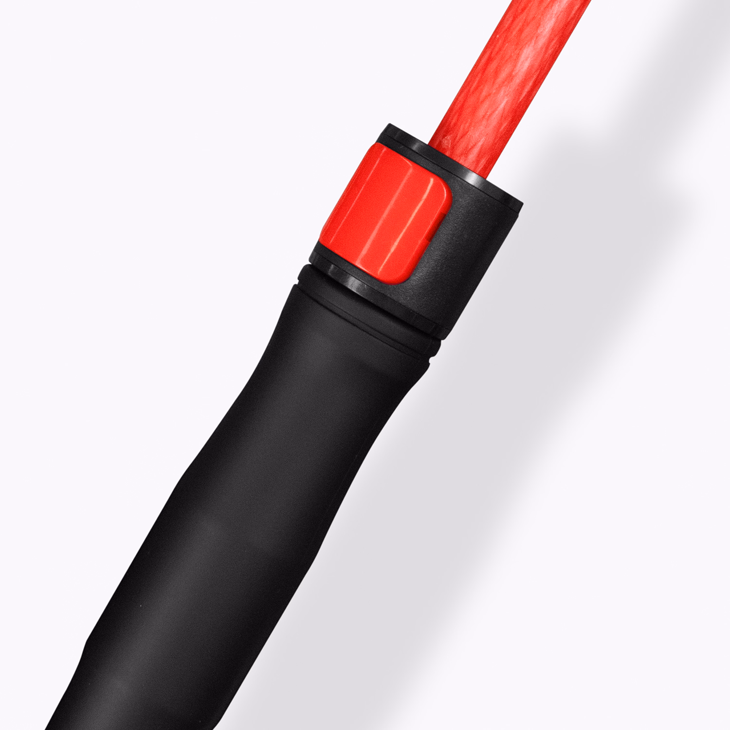 Close-up of Monsoon umbrella handle in black with red shaft and push button